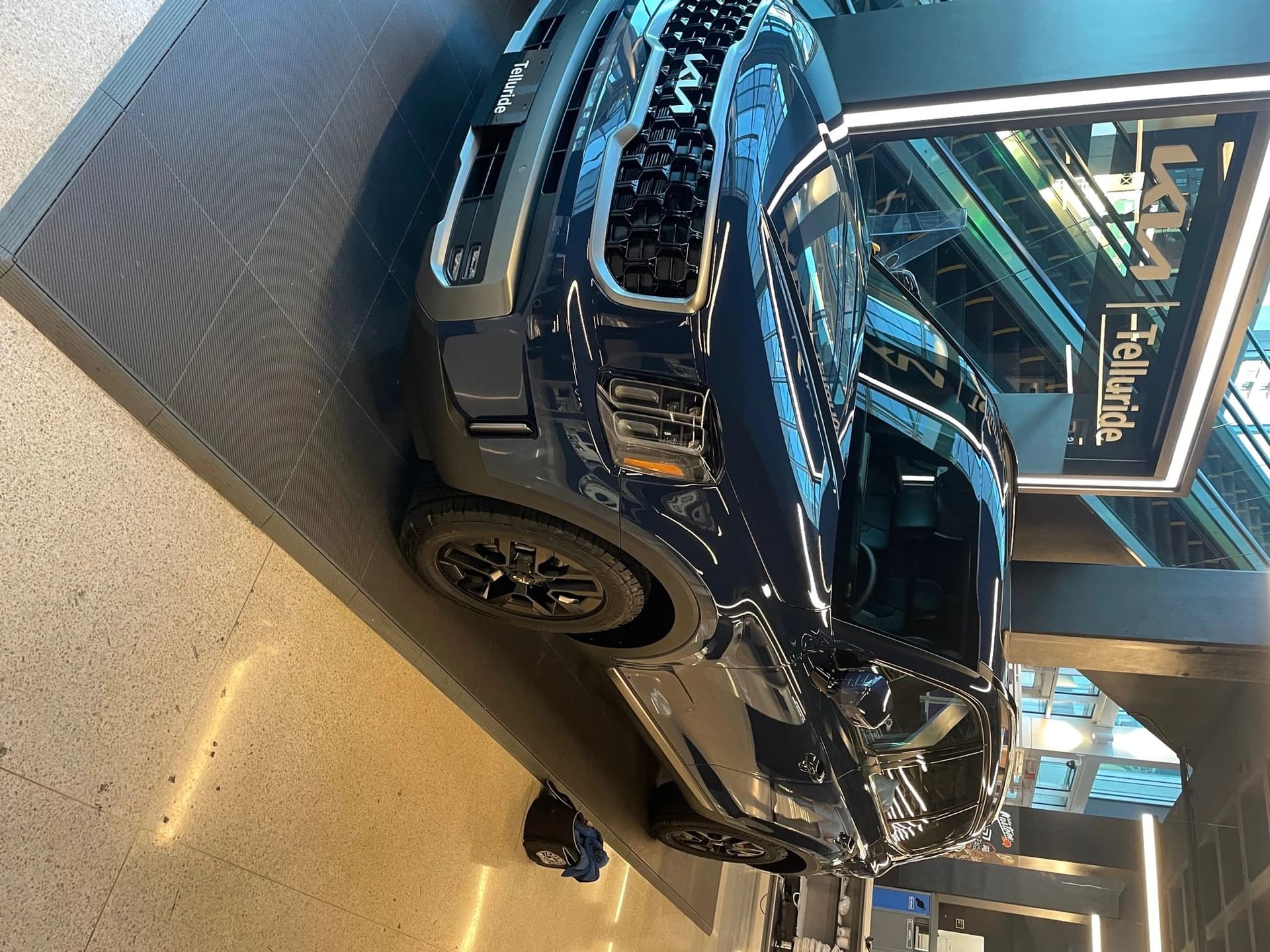 A freshly detailed, glossy dark SUV reflecting the showroom lights after a Gabe's detail